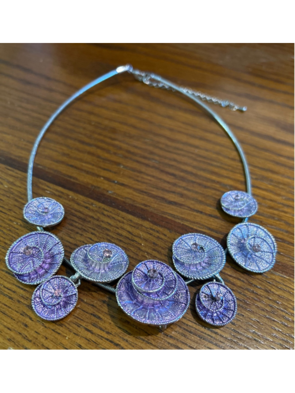 silver-colored choker chain adorned with multiple purple, spiral-shaped dangly